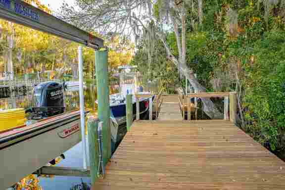 Wooden main dock leading to a floating dock at Hideout Heights Rental, with boats ready for an adventure.