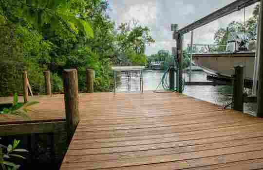 Wooden dock at Hideout Heights with a fish cleaning table and a boat lift, right by the water.