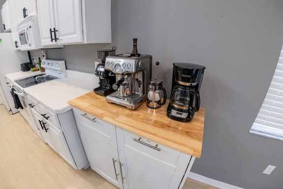 Cozy coffee bar corner with espresso machine and coffee maker at Hideout Heights Vacation Rental, ready to energize your mornings.