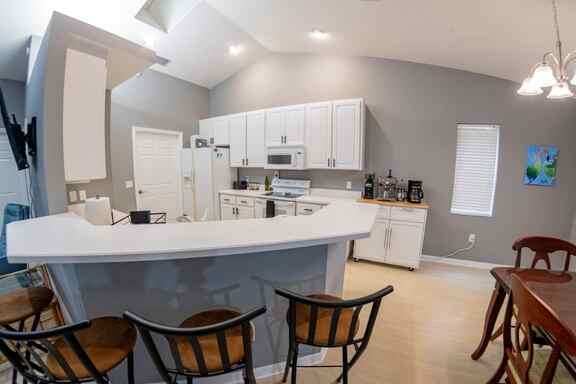 Contemporary kitchen seen from the bar area with comfortable seating at Hideout Heights Vacation Rental, perfect for casual dining.