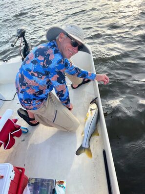 Smiling angler with a freshly caught snook on a boat at Hideout Heights.